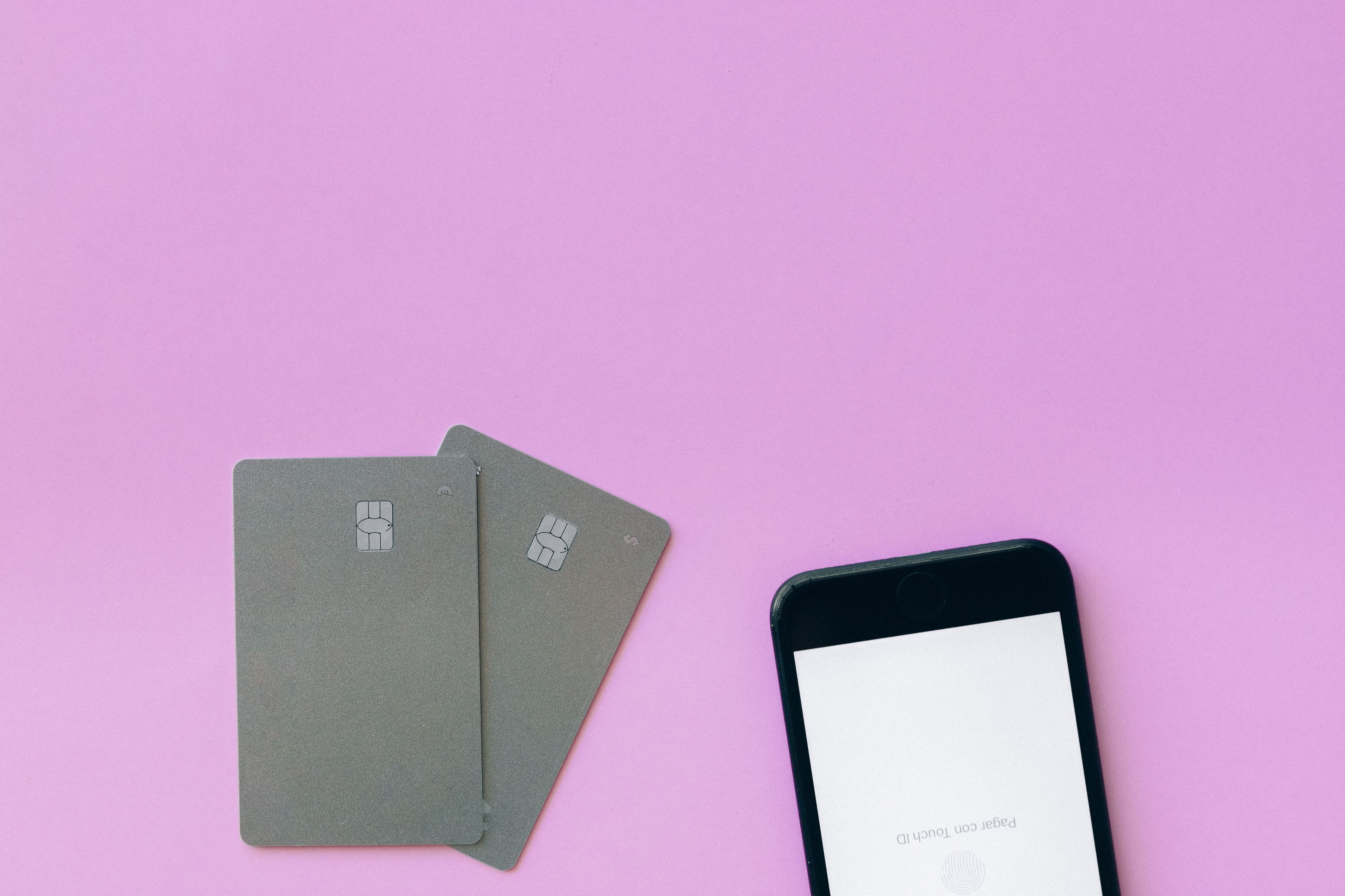 Payment cards and phone on a pink background